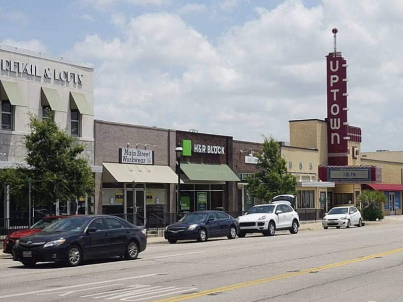 Quail Crossing Small town street with various storefronts and the Uptown Theater.
